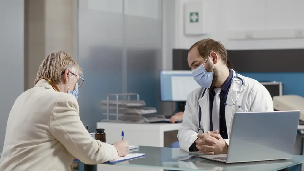A patient going through paperwork with a doctor at a consultation