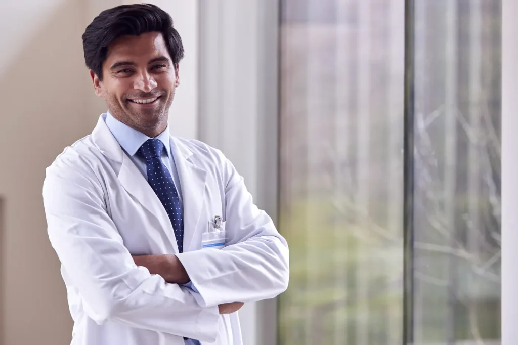 A doctor in a white coat standing by a window